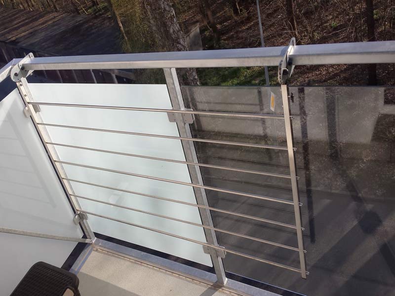 Suszarka balkonowa zamontowana na balustradzie ze szklanym wypełnieniem